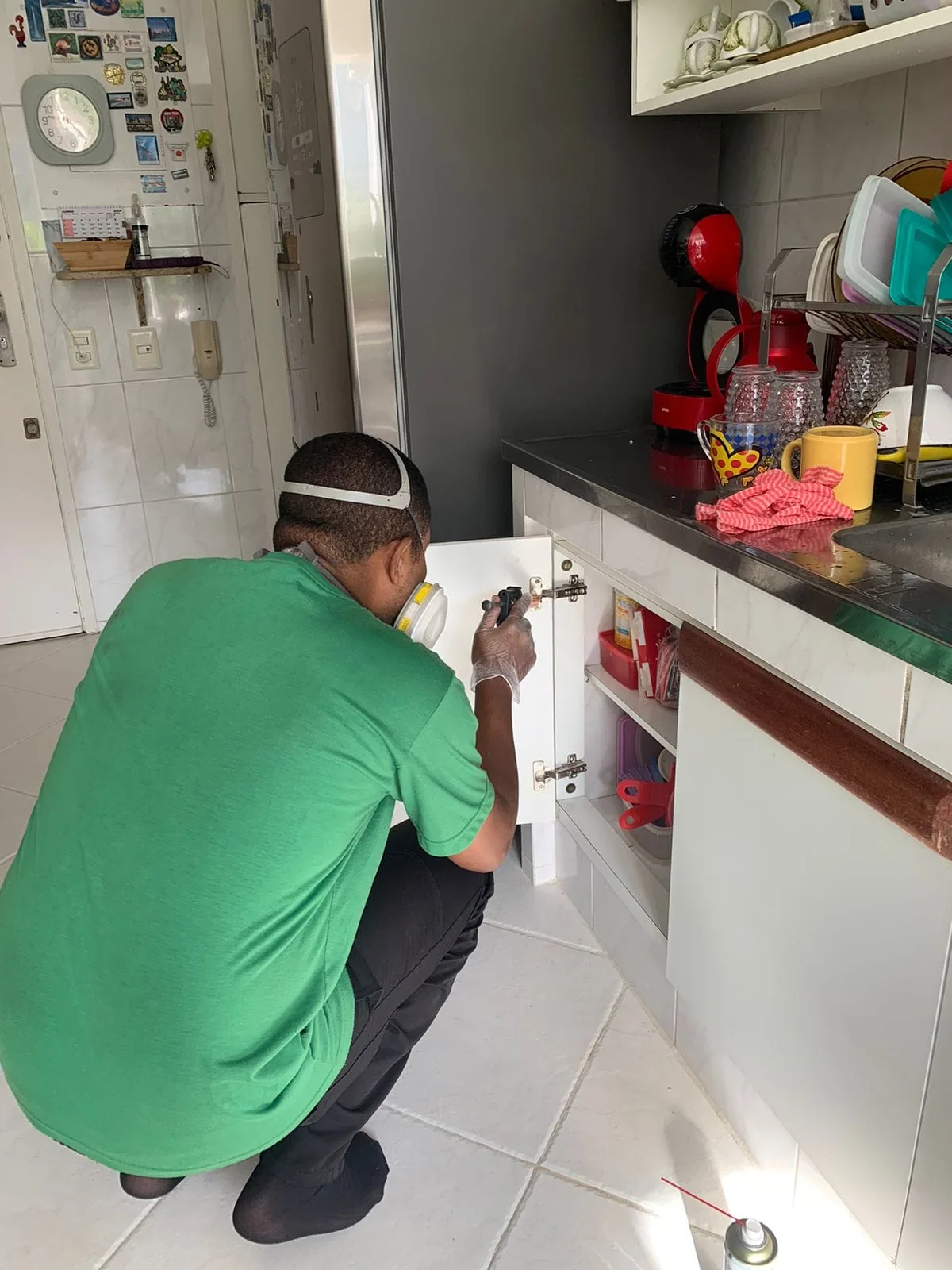 Técnico realizando aplicação direcionada em armário de cozinha