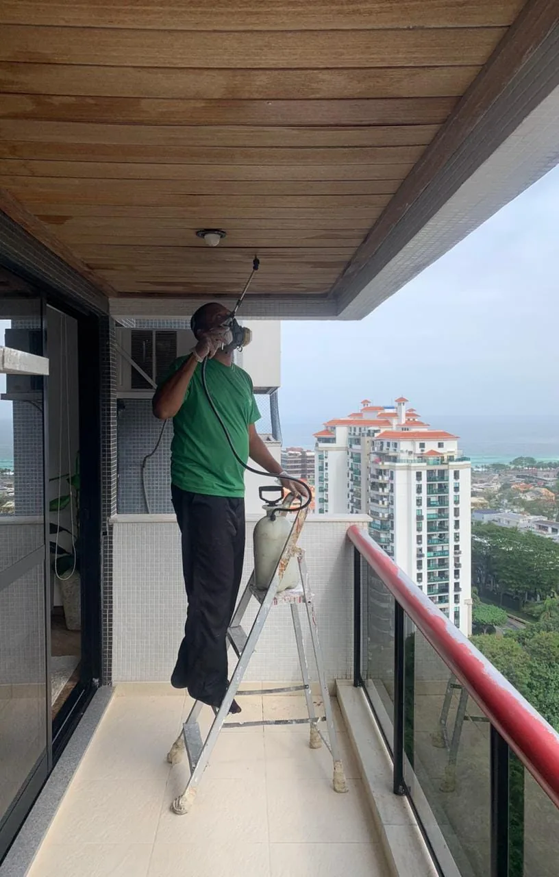 Técnico aplicando produto em varanda de condomínio no Rio de Janeiro